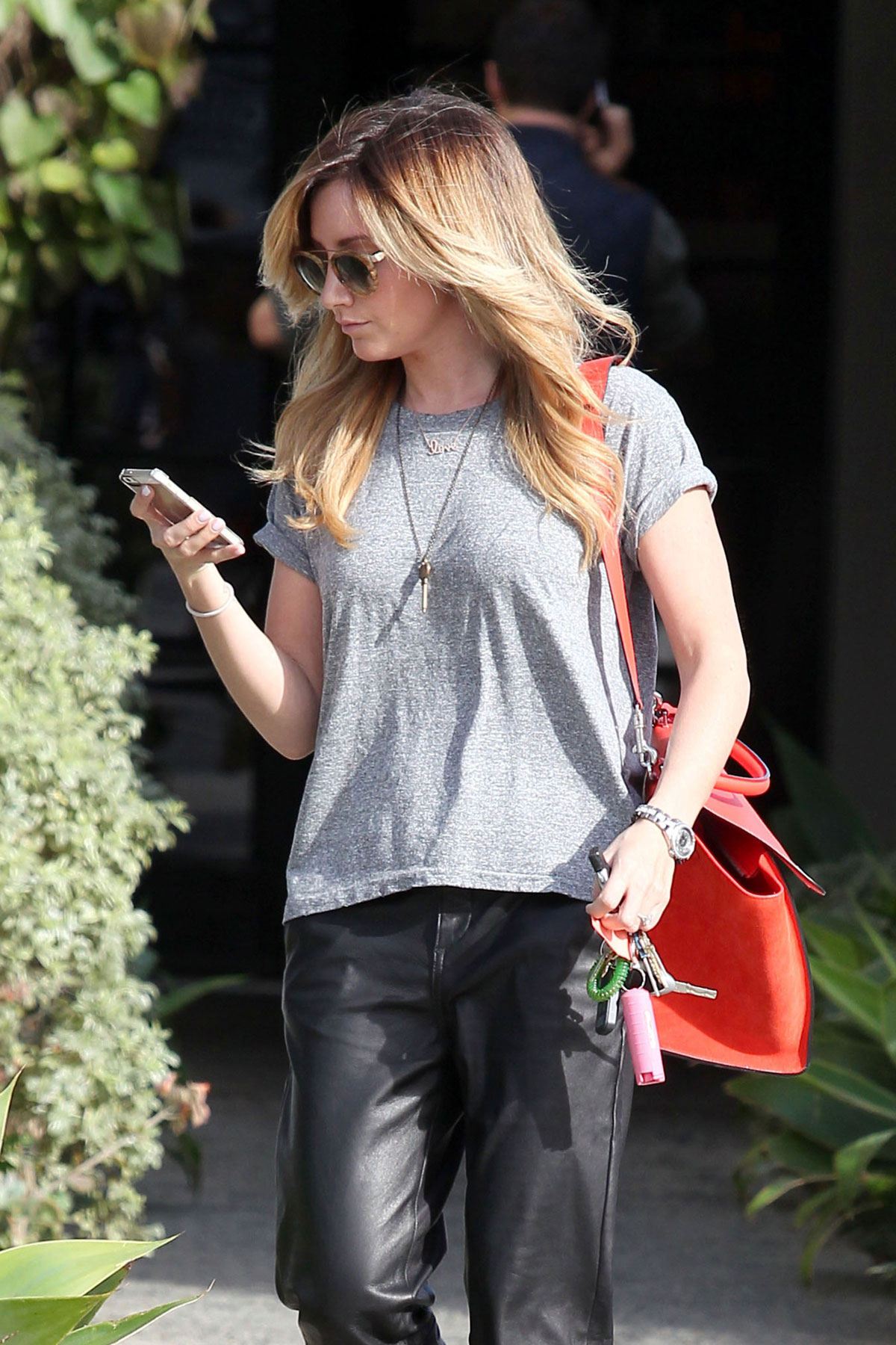Ashley Tisdale checks out her iPhone as she runs errands around