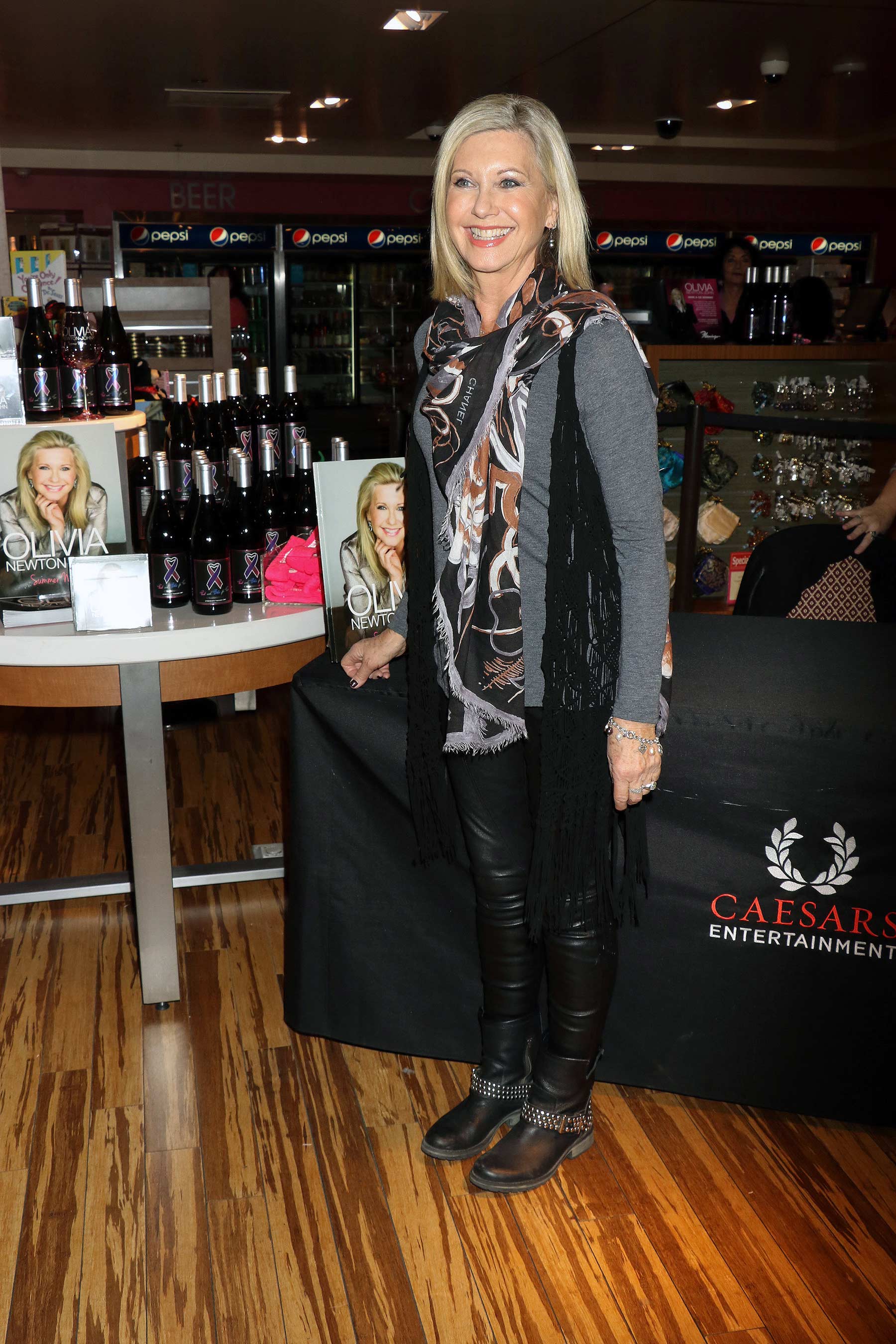 Olivia Newton John signs bottles and CDs