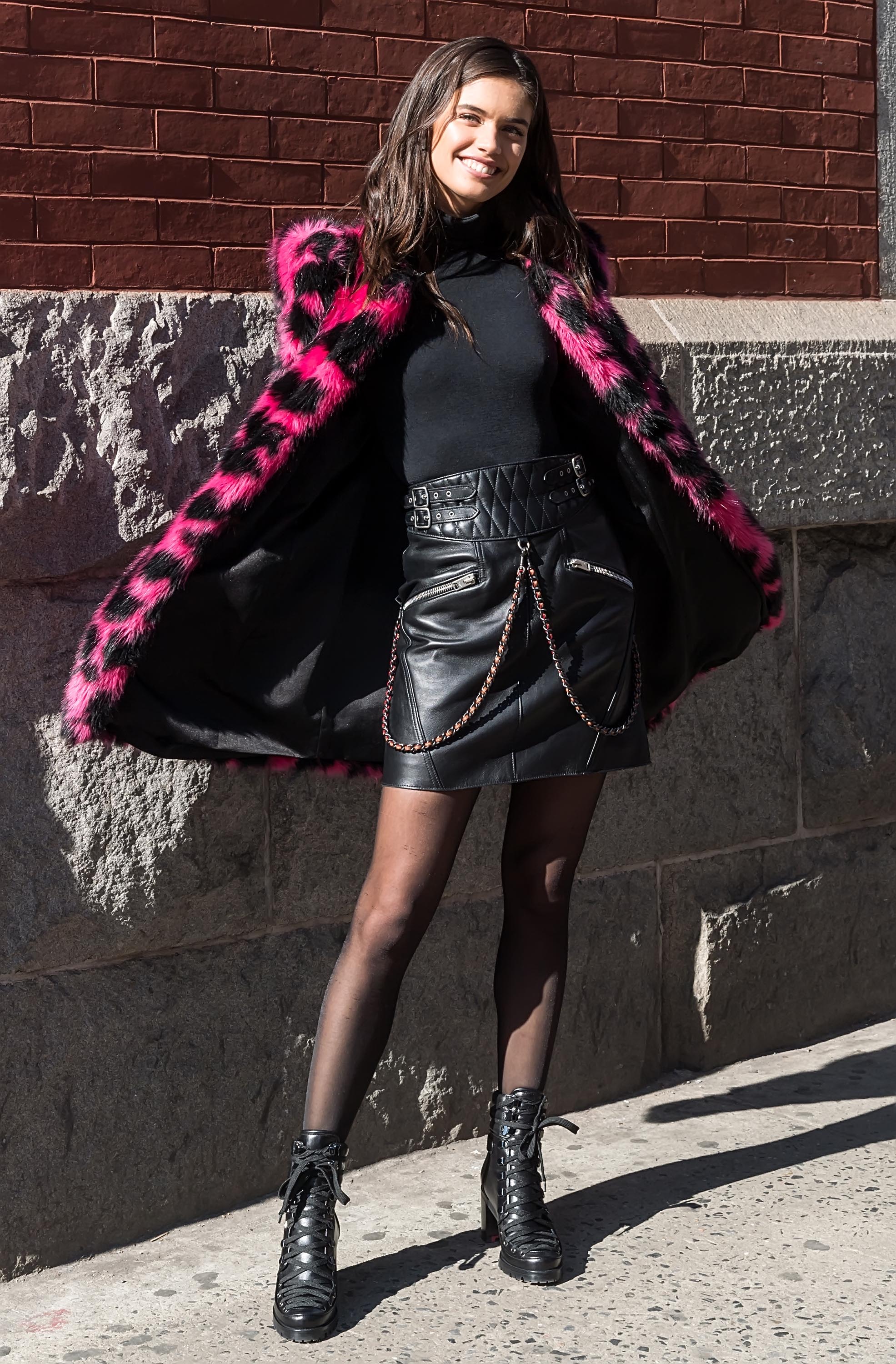 Sara Sampaio wearing a pink black leoprint coat outside Marc Jacobs